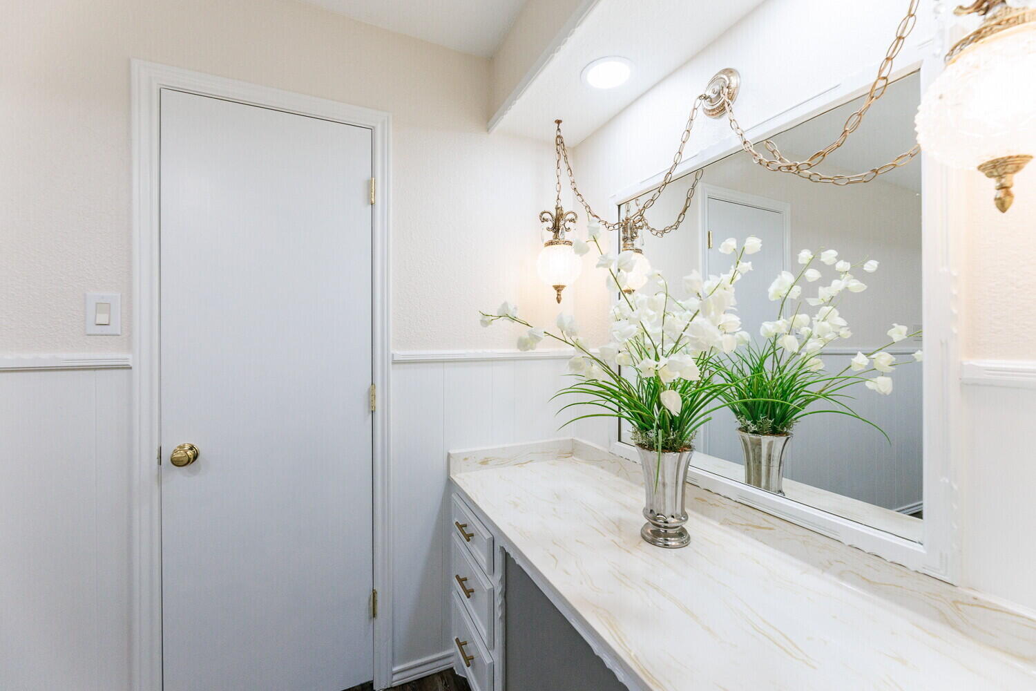 5703 80th Street Lubbock, TX 79424 - Photo 27 of 52 a bathroom with a sink a mirror and a potted plant
