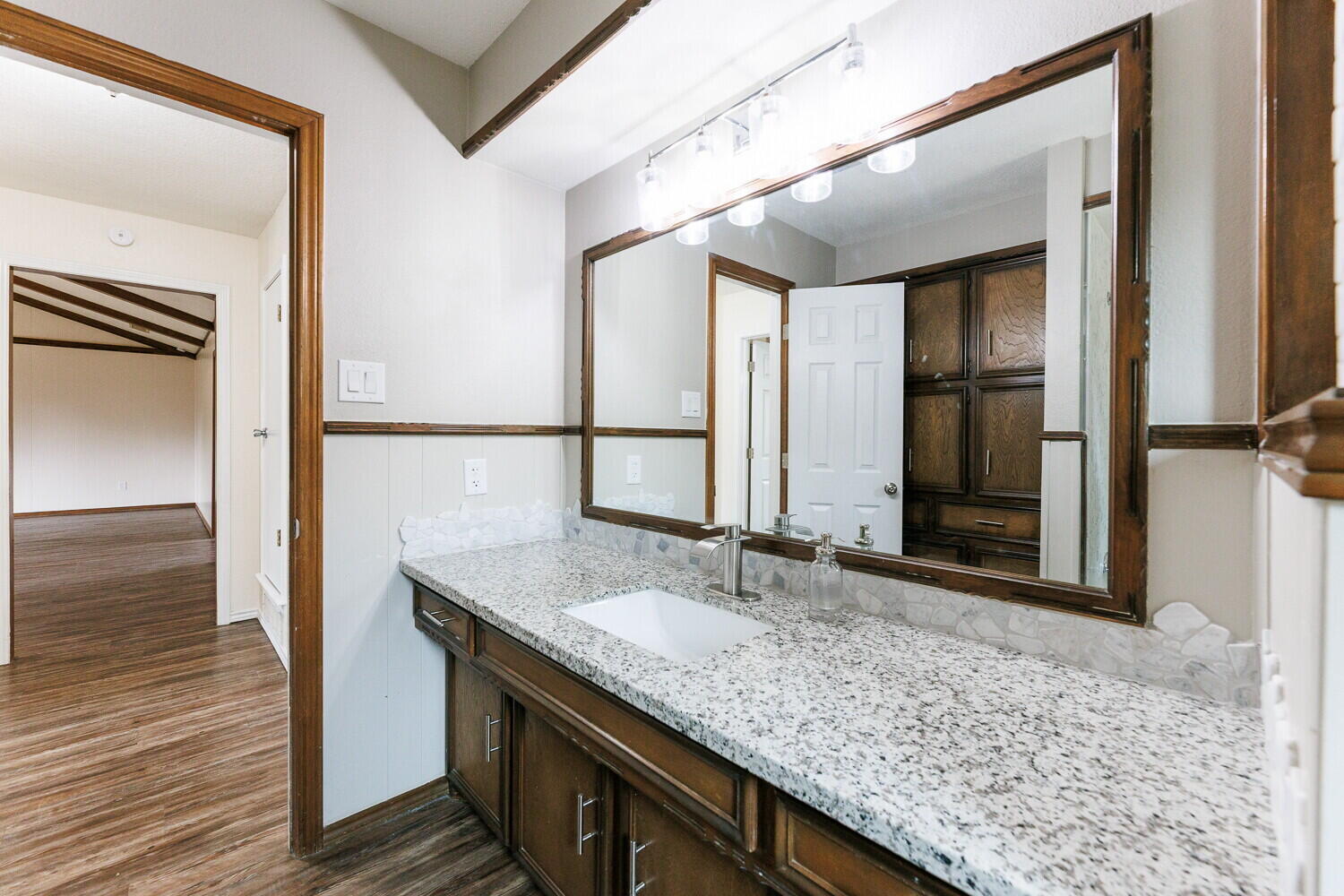 5703 80th Street Lubbock, TX 79424 - Photo 40 of 52 a bathroom with a granite countertop sink and a mirror