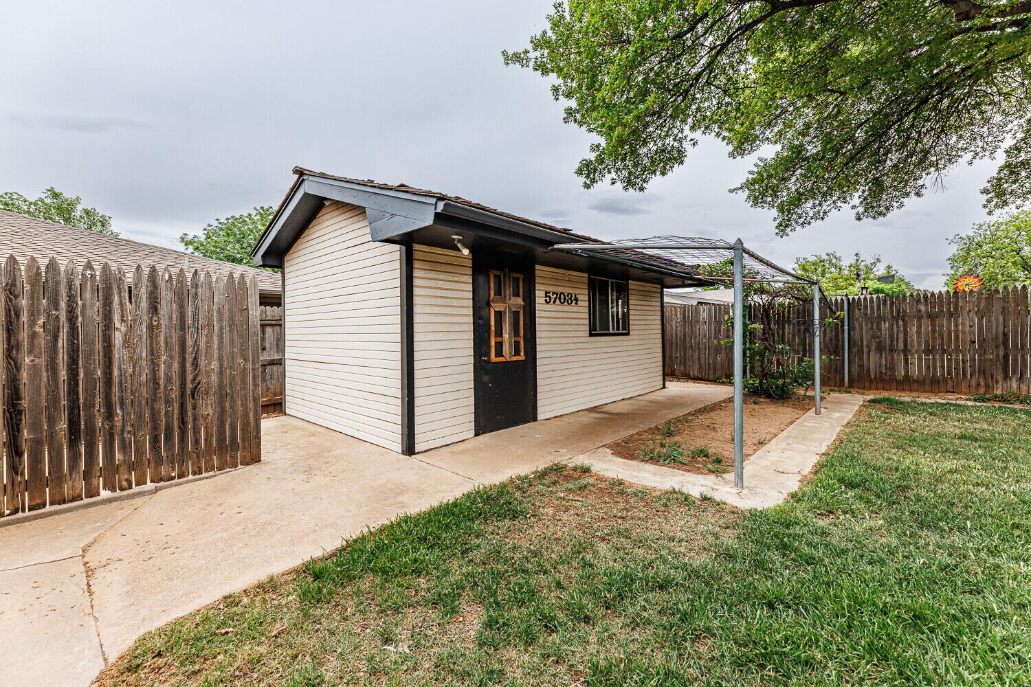 5703 80th Street Lubbock, TX 79424 - Photo 48 of 52 a view of a white house with a small yard and large tree