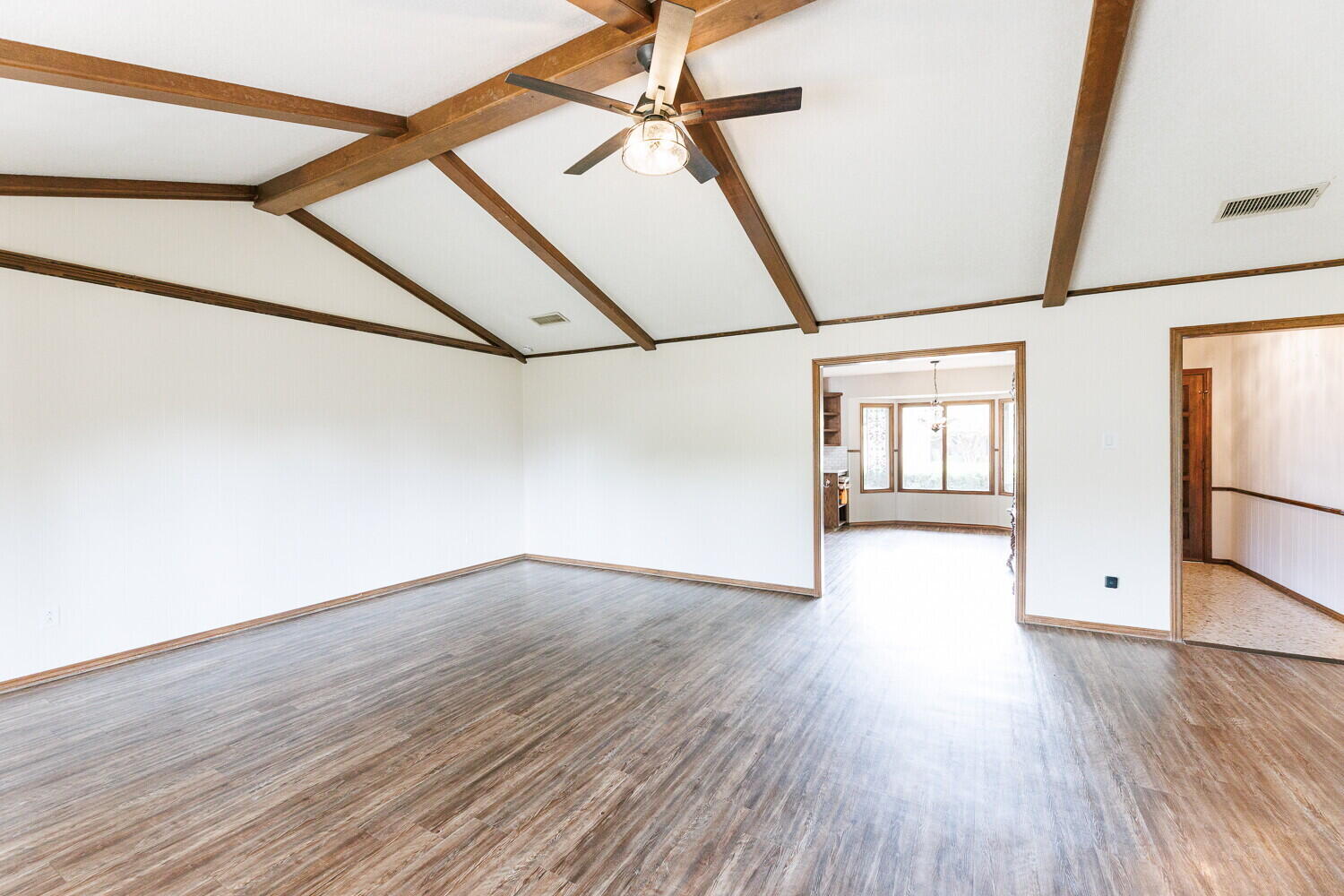 5703 80th Street Lubbock, TX 79424 - Photo 6 of 52 a view of an empty room with wooden floor and a window