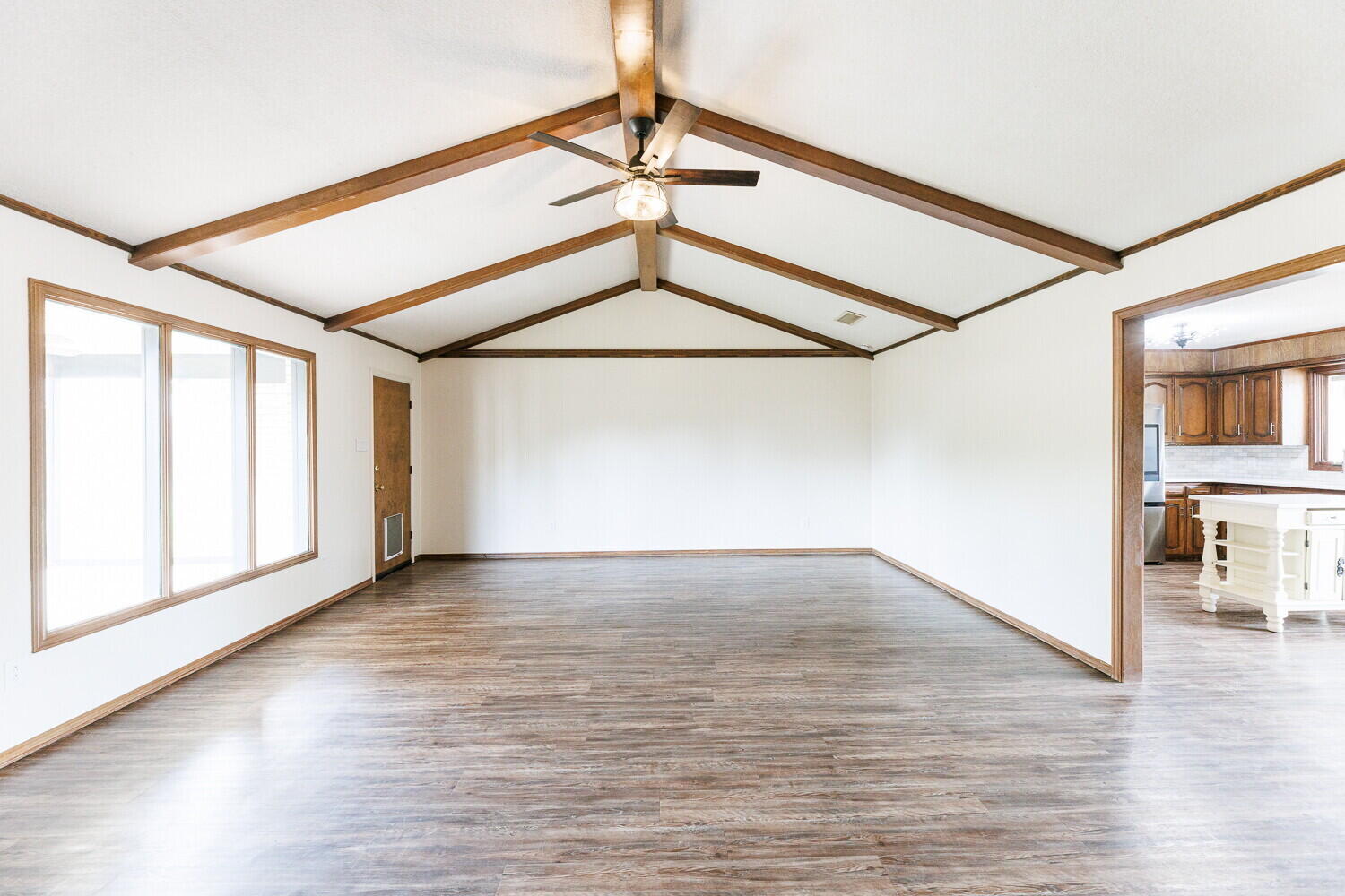 5703 80th Street Lubbock, TX 79424 - Photo 7 of 52 a view of an empty room with a window and wooden floor