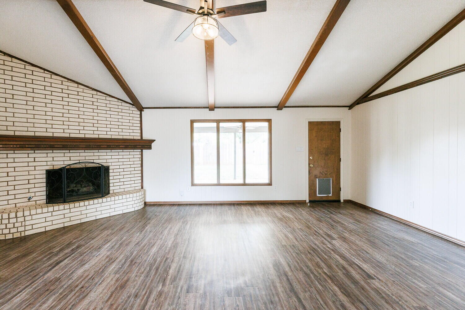 5703 80th Street Lubbock, TX 79424 - Photo 9 of 52 a view of an empty room with wooden floor fireplace and a window