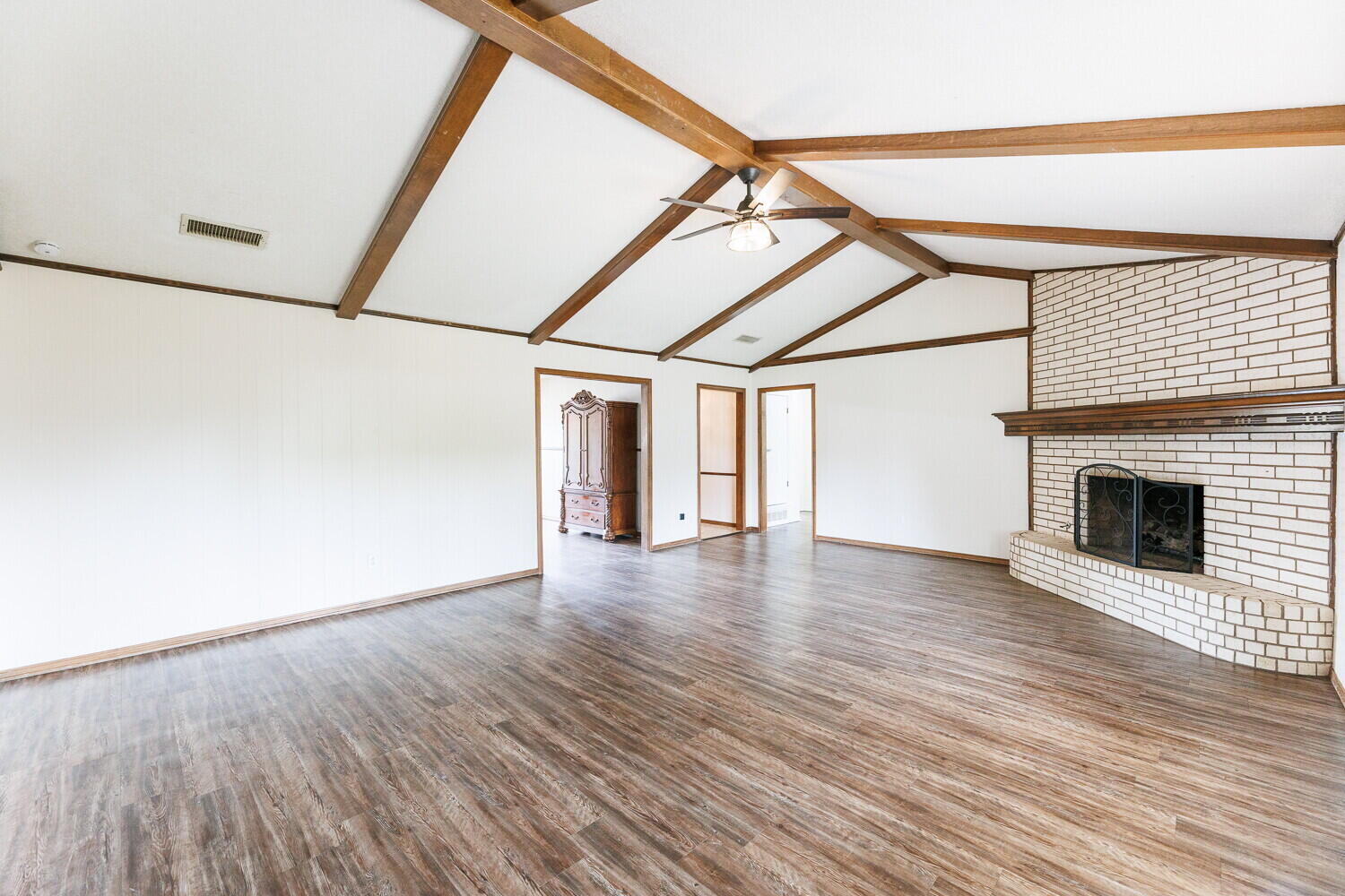 5703 80th Street Lubbock, TX 79424 - Photo 10 of 52 an empty room with wooden floor and fireplace