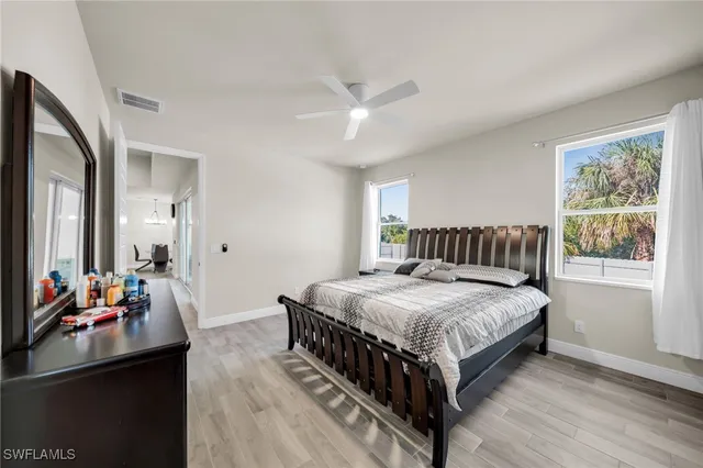 a bedroom with a bed and a dresser next to a window