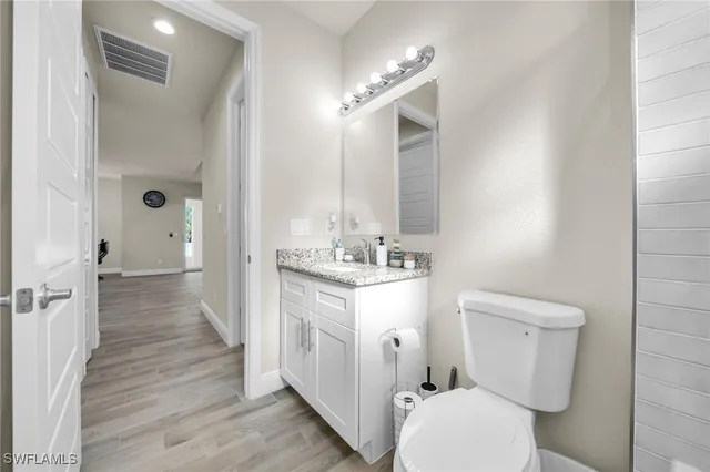 a bathroom with a sink a toilet a mirror and shower