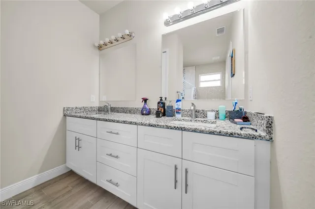 a bathroom with double sink and a mirror