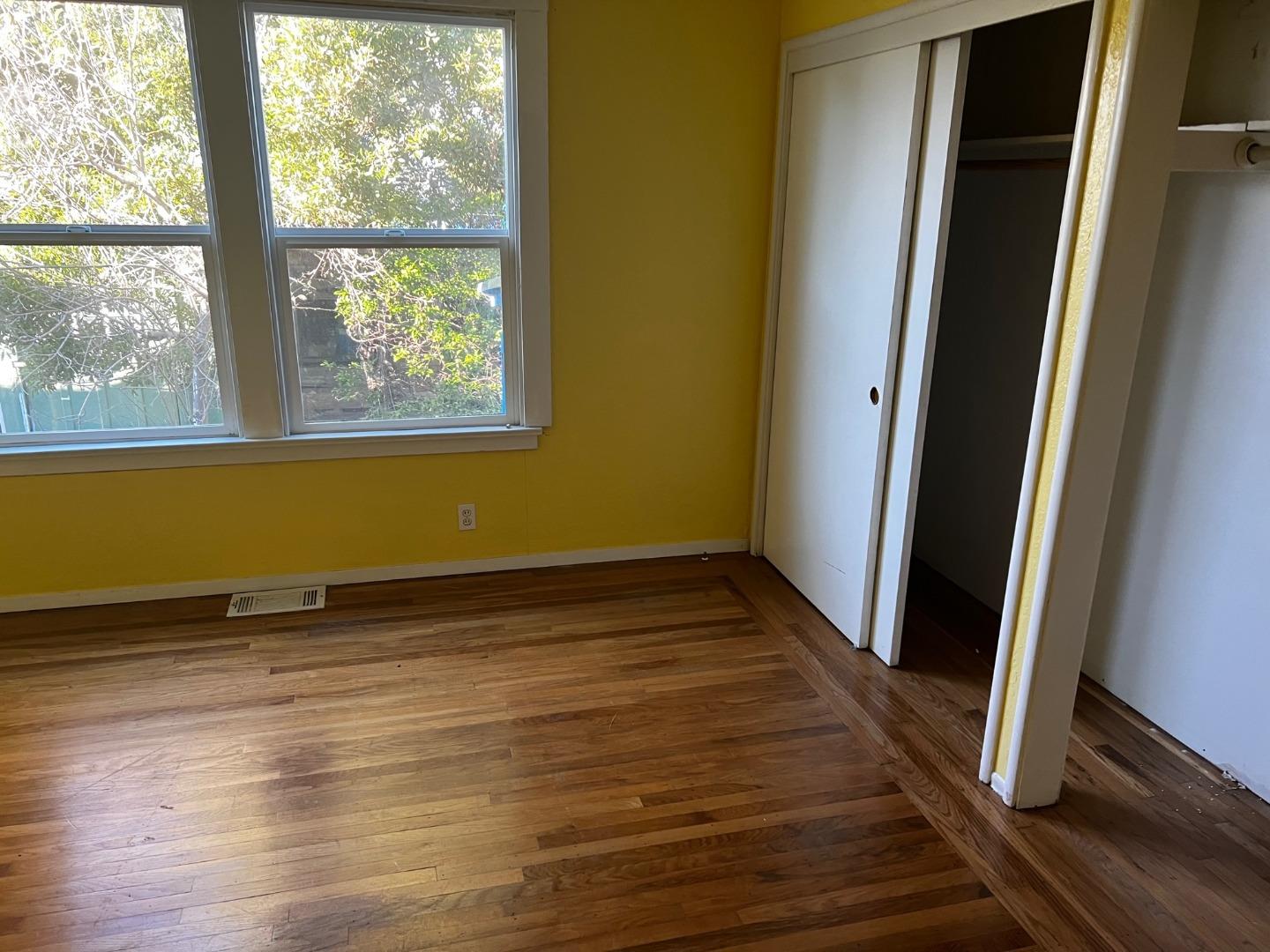 917 Channing Way Berkeley, CA 94710 - Photo 4 of 15 a view of an empty room with wooden floor and a window