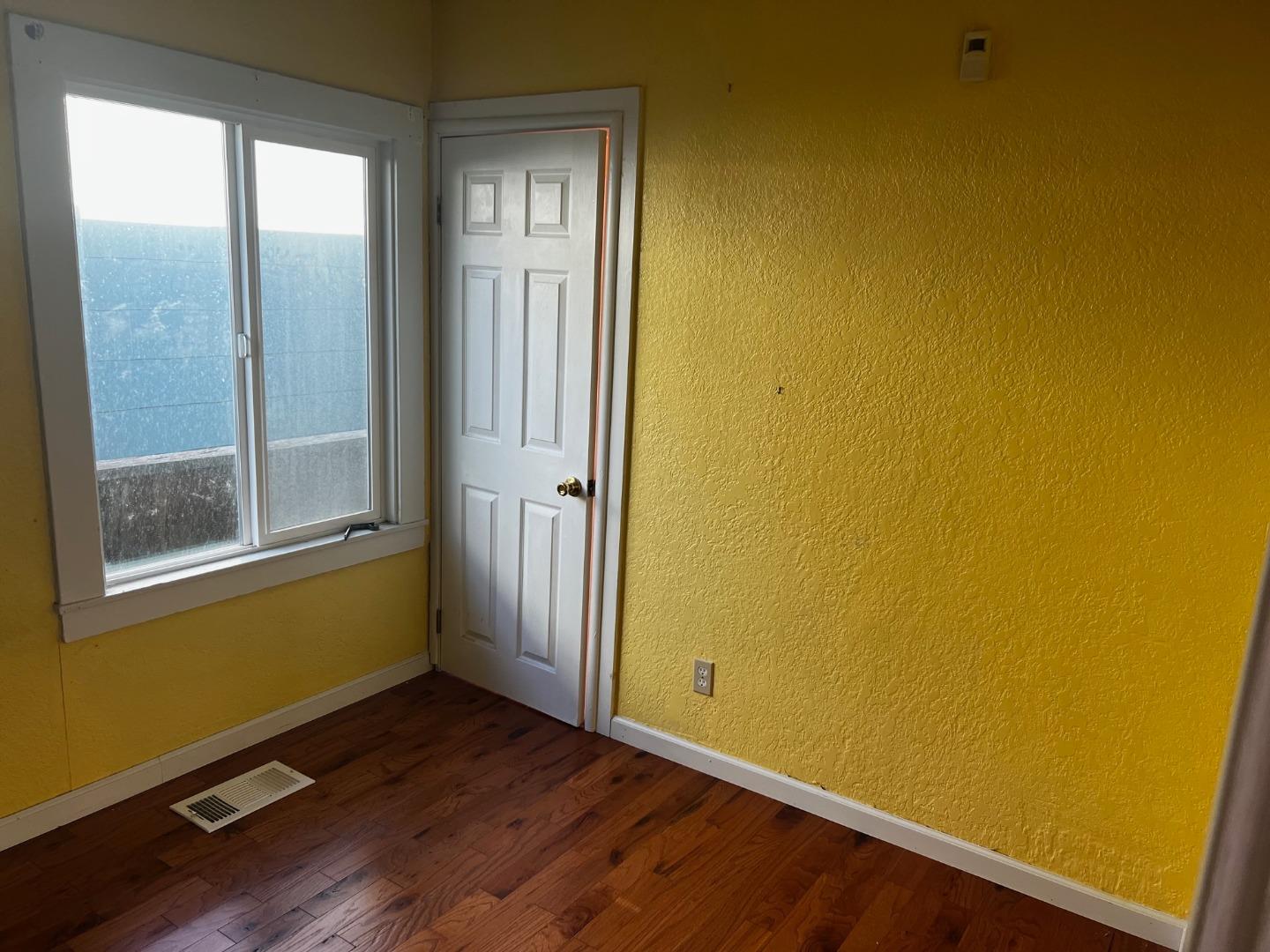 917 Channing Way Berkeley, CA 94710 - Photo 6 of 15 an empty room with wooden floor and windows