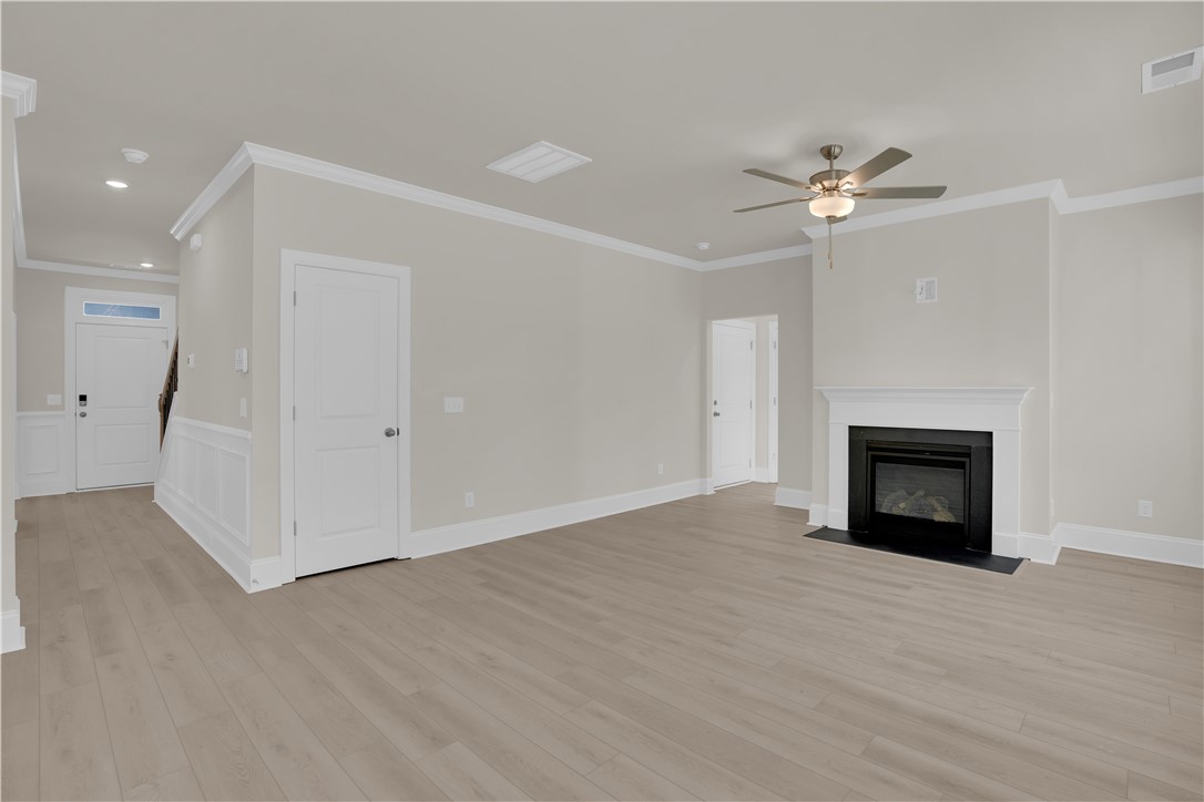 202 Bellflower Lane Pendleton, SC 29670 - Photo 16 of 38 This bright interior features crown molding, wood flooring, and a cozy fireplace, creating an inviting atmosphere.