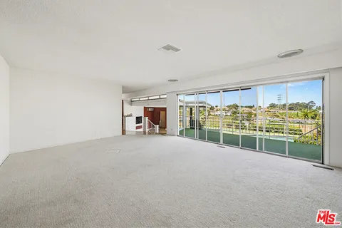 a view of a big room with windows and kitchen view