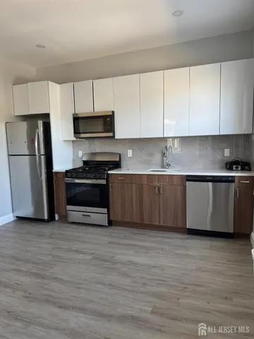a kitchen with stainless steel appliances a stove a sink and a refrigerator