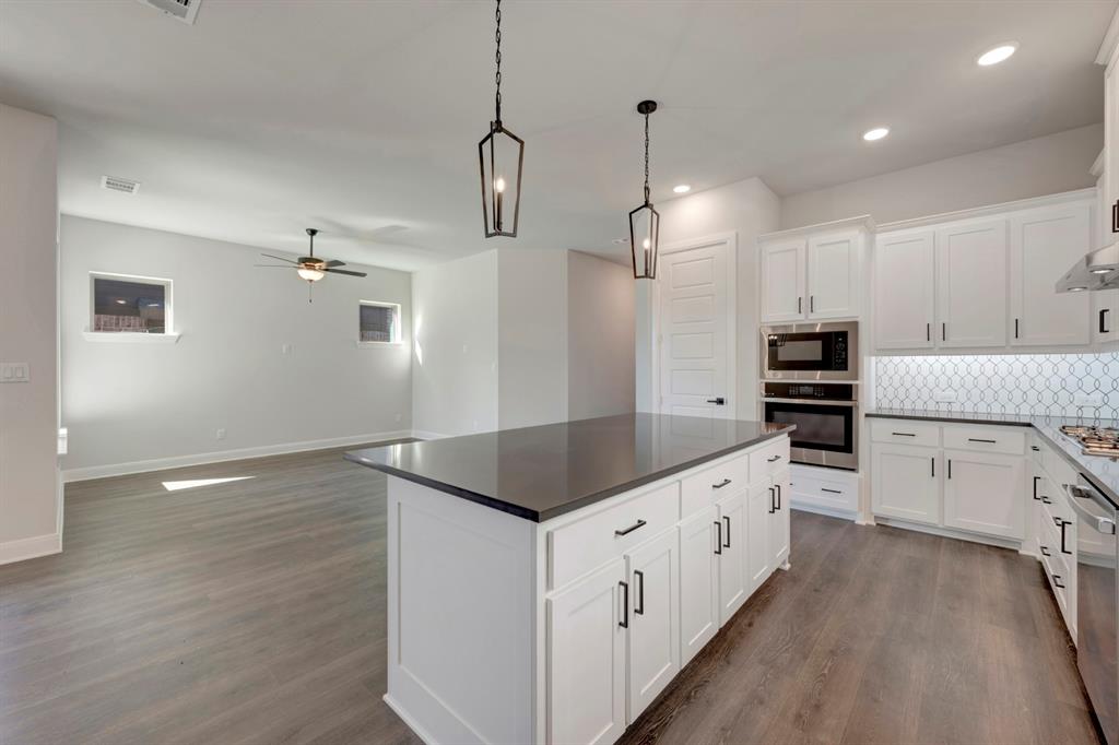 1857 Lightner Road Van Alstyne, TX 75495 - Photo 18 of 29 a kitchen with stove cabinets and wooden floor