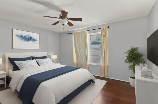 a bedroom with a large bed and a potted plant