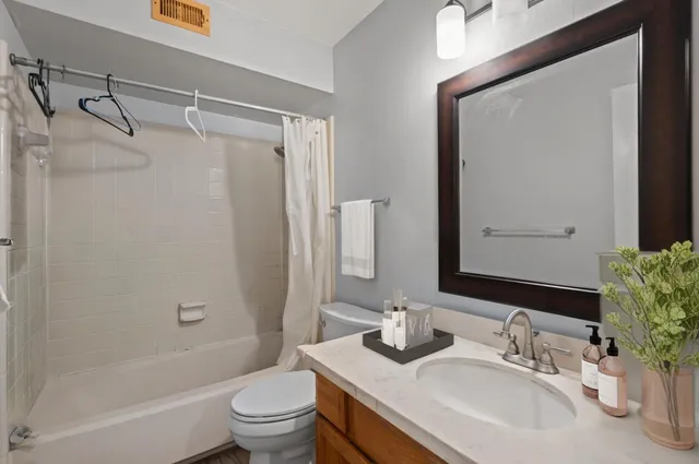 a bathroom with a granite countertop sink toilet and shower
