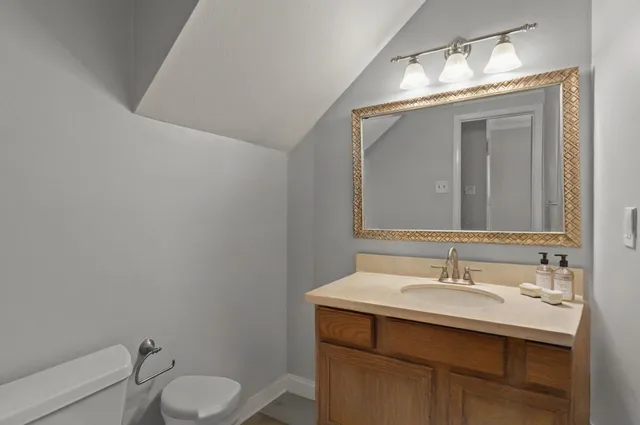 a bathroom with a sink toilet and mirror