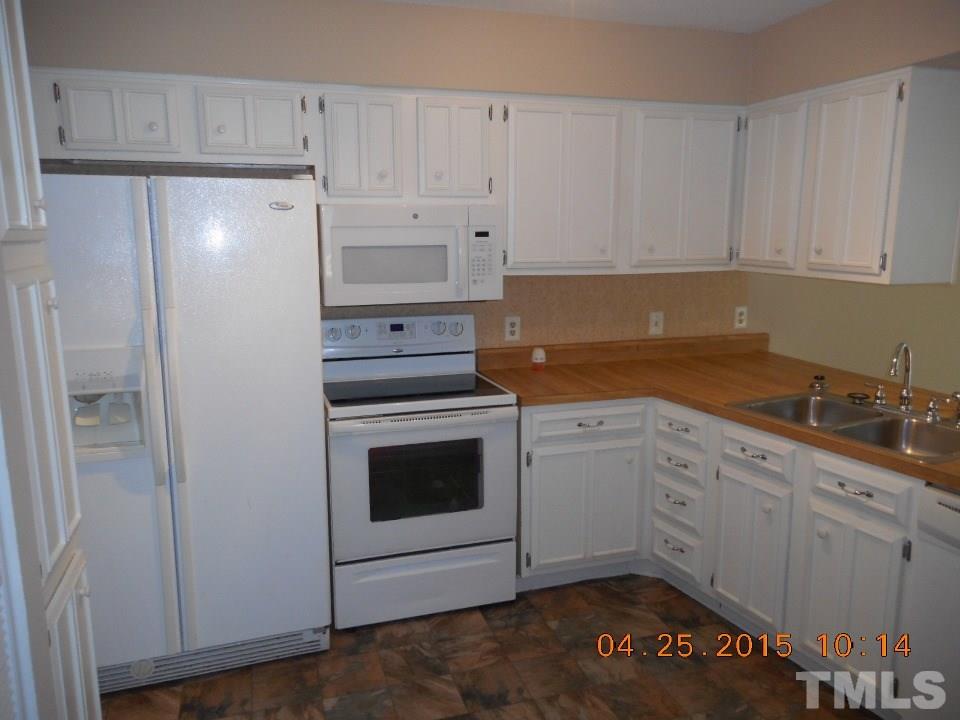 808 Green Ridge Drive Raleigh, NC 27609 - Photo 5 of 10 a kitchen with granite countertop white cabinets and white appliances