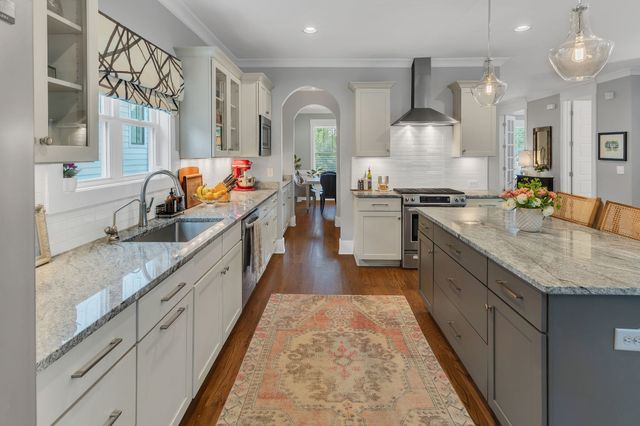 a large kitchen with stainless steel appliances granite countertop a sink stove and cabinets