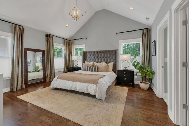 a spacious bedroom with a large bed and a chandelier