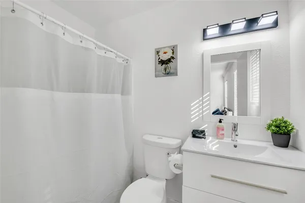 a bathroom with a sink mirror and toilet