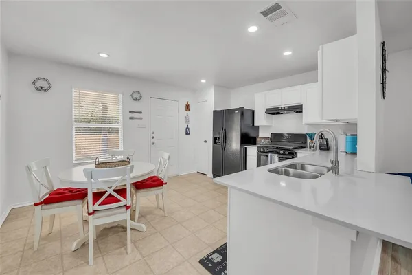 a kitchen with stainless steel appliances kitchen island granite countertop a sink refrigerator and cabinets