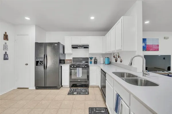 a kitchen with a sink a refrigerator and cabinets