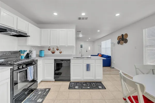 a kitchen with a stove a sink and cabinets