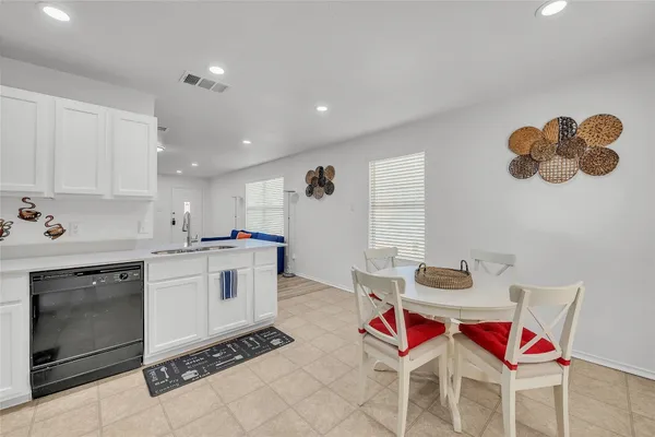 a kitchen with a sink dining table and chairs