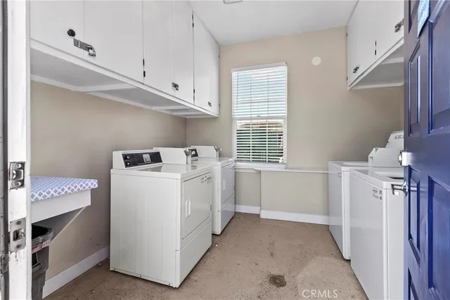 a utility room with cabinets washer and dryer