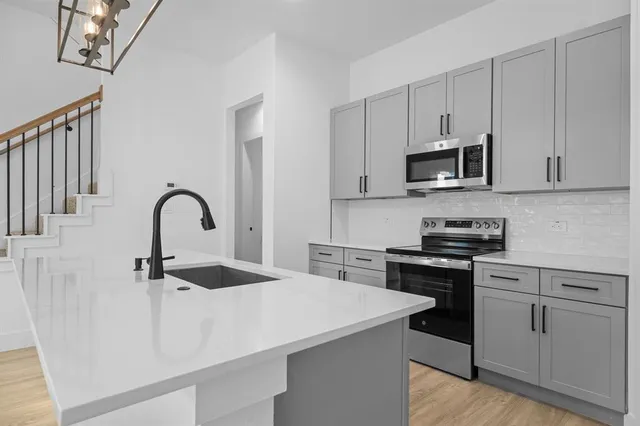 a kitchen with kitchen island a sink appliances and cabinets