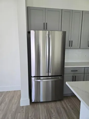 a metallic refrigerator freezer sitting in a kitchen