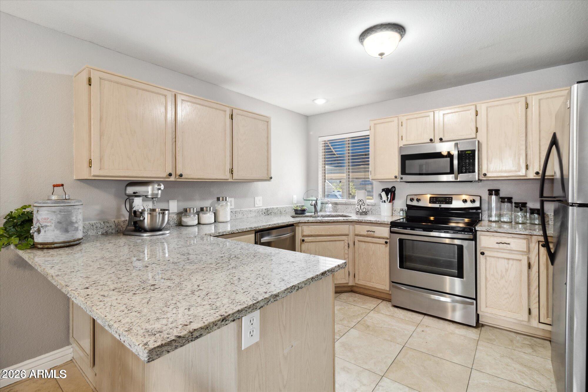 a kitchen with kitchen island granite countertop a stove sink and microwave