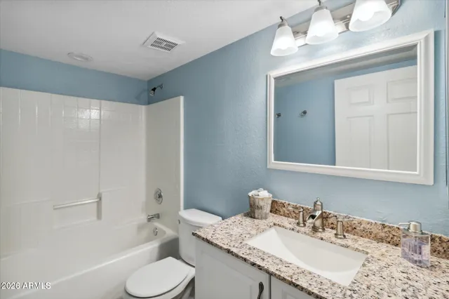 a bathroom with a granite countertop sink toilet and shower