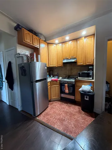 a kitchen with granite countertop a refrigerator stove and sink