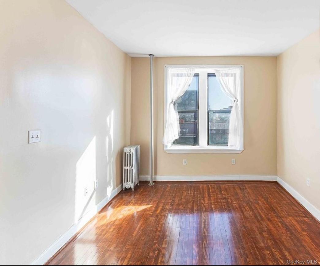2913 Foster Avenue, Unit 6F Brooklyn, NY 11210 - Photo 5 of 5 an empty room with wooden floor and windows
