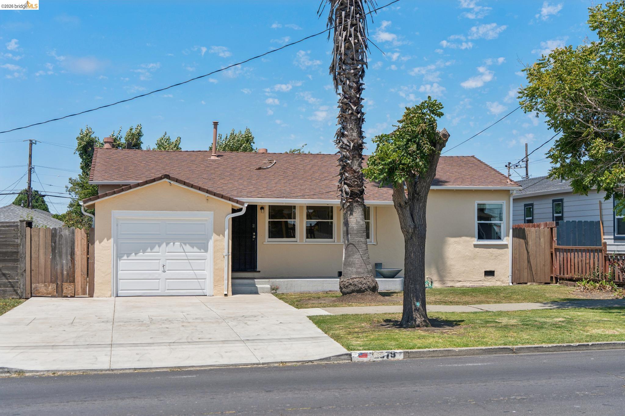 2879 Rheem Avenue Richmond, CA 94804 - Photo 2 of 45 Single-story residence featuring a light-colored stucco exterior, attached garage, and a brown shingle roof