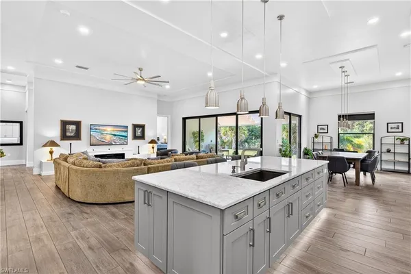 a living room with furniture kitchen and a large window