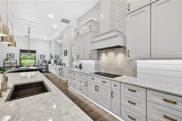 a kitchen with granite countertop a sink a stove and cabinets