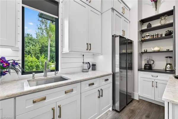 a kitchen with white cabinets and a window