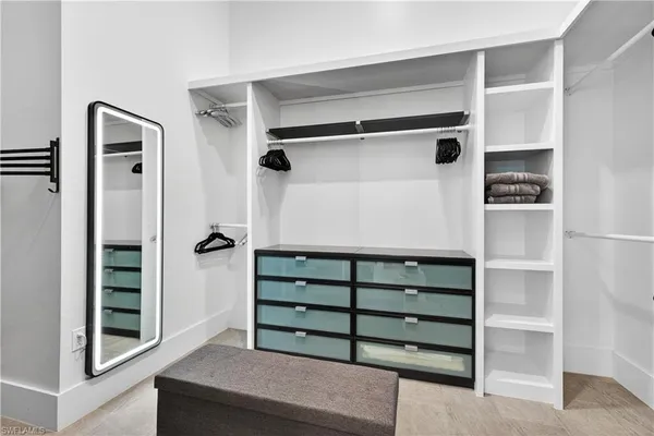 a bedroom with a bed a mirror on dresser and a window