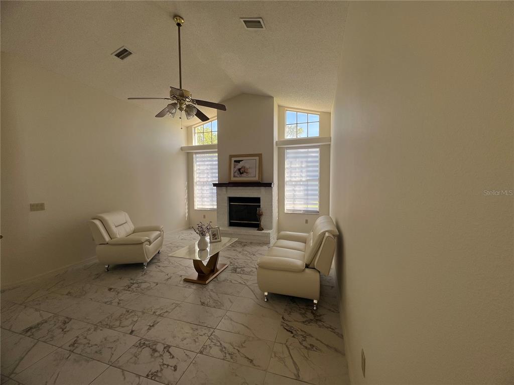 14189 Cornewall Lane Spring Hill, FL 34609 - Photo 11 of 36 a living room with furniture and a fireplace