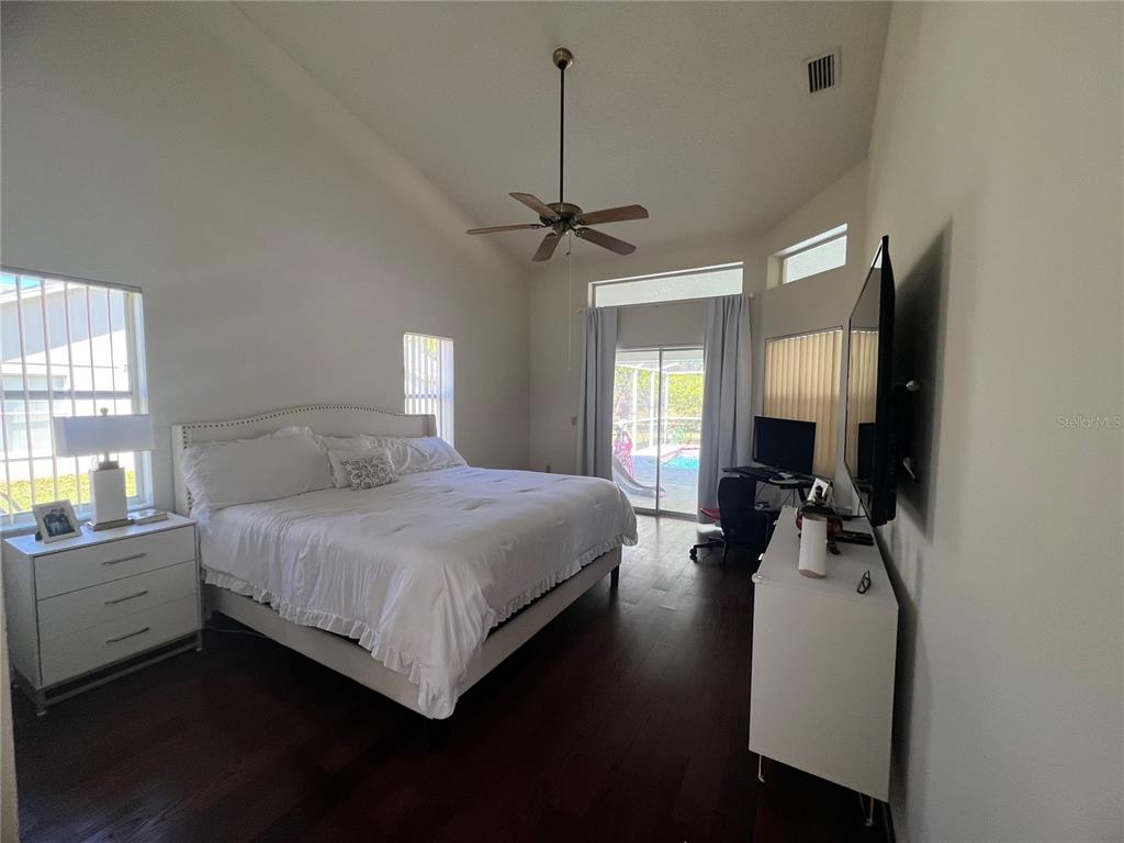 14189 Cornewall Lane Spring Hill, FL 34609 - Photo 17 of 36 a bedroom with a bed window and a chandelier