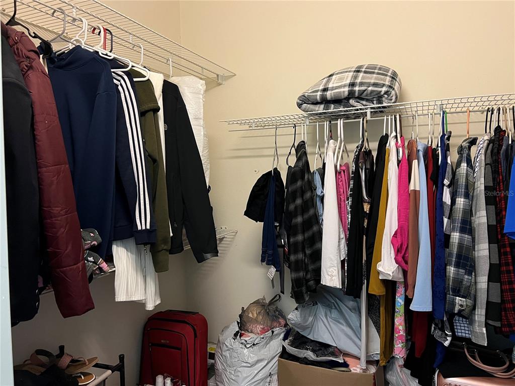 14189 Cornewall Lane Spring Hill, FL 34609 - Photo 19 of 36 a view of walk in closet with clothes and shoes