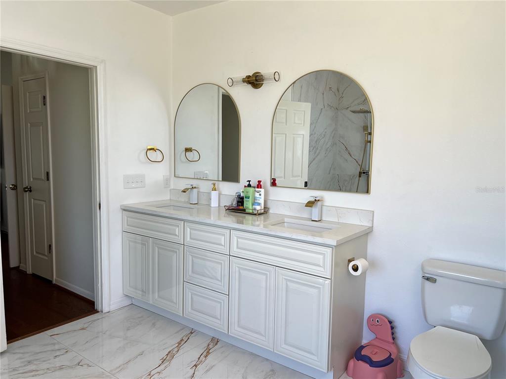 14189 Cornewall Lane Spring Hill, FL 34609 - Photo 21 of 36 a spacious bathroom with a double vanity sink and a mirror