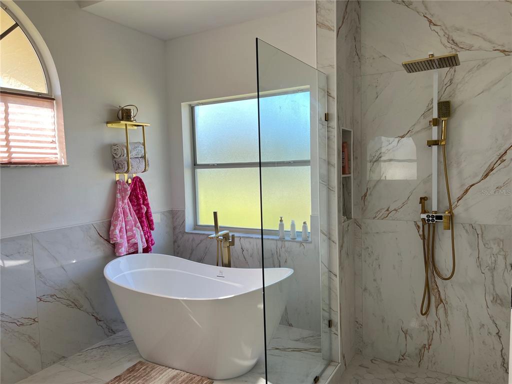 14189 Cornewall Lane Spring Hill, FL 34609 - Photo 23 of 36 a bathroom with a tub and shower
