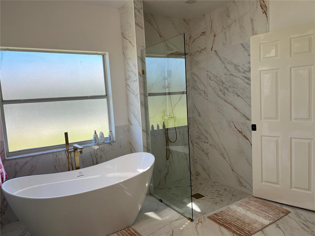 14189 Cornewall Lane Spring Hill, FL 34609 - Photo 24 of 36 a bathroom with a bathtub and shower