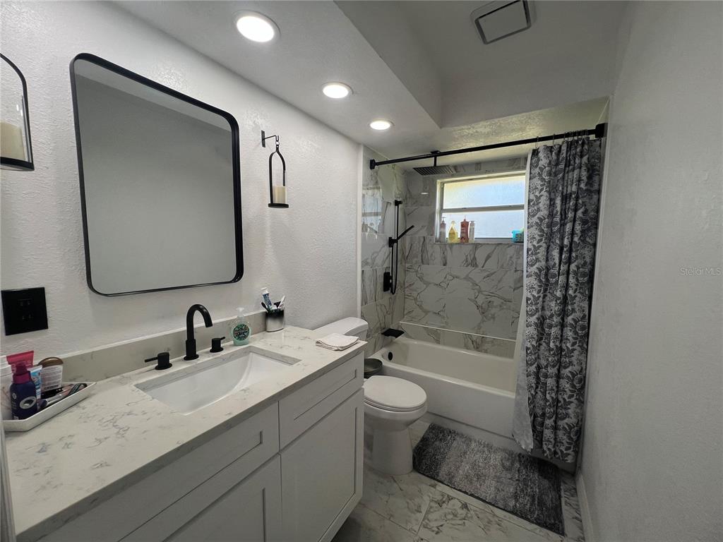14189 Cornewall Lane Spring Hill, FL 34609 - Photo 26 of 36 a bathroom with a double vanity sink toilet mirror and shower