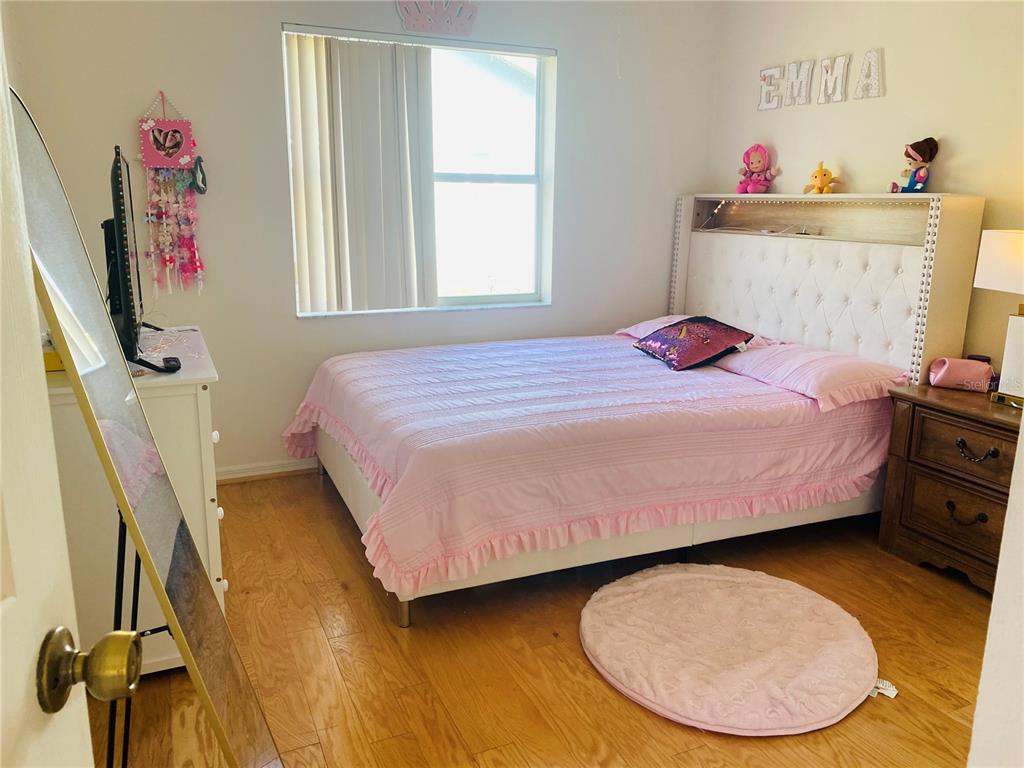 14189 Cornewall Lane Spring Hill, FL 34609 - Photo 27 of 36 a bedroom with a bed and a chandelier