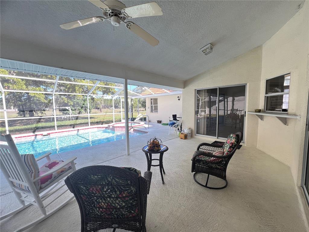 14189 Cornewall Lane Spring Hill, FL 34609 - Photo 29 of 36 a living room with furniture and a floor to ceiling window