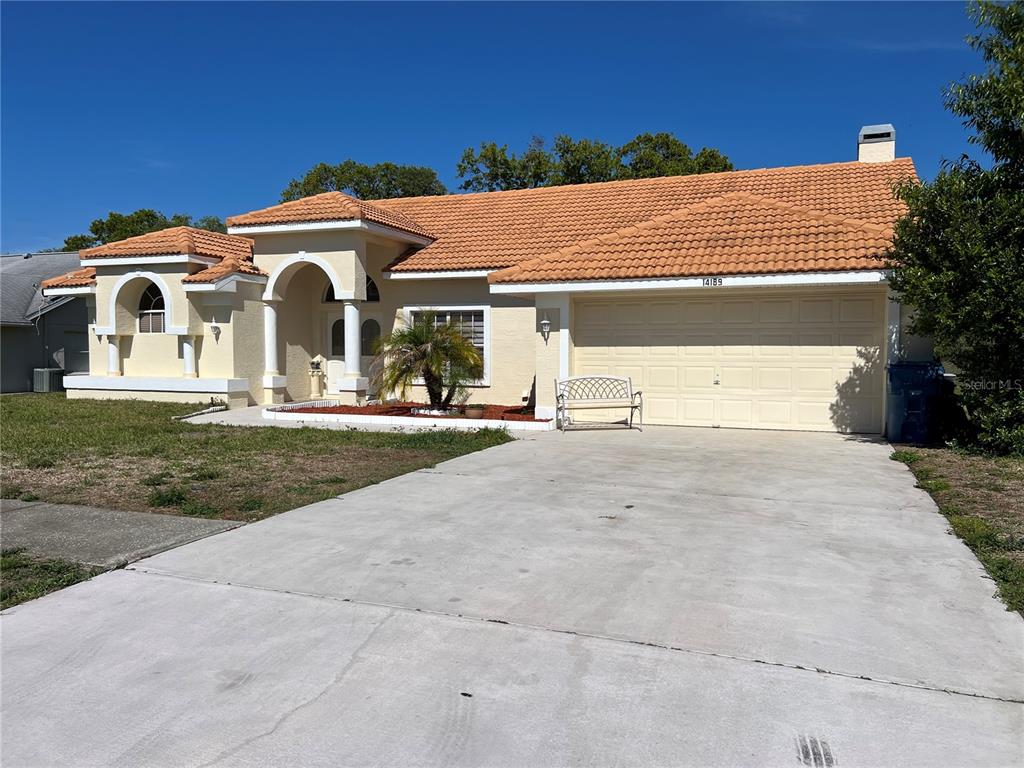 14189 Cornewall Lane Spring Hill, FL 34609 - Photo 3 of 36 a view of a white house with a yard