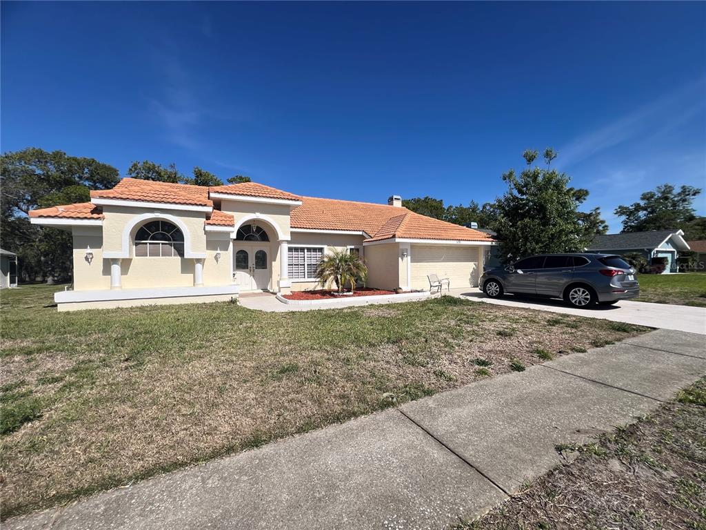 14189 Cornewall Lane Spring Hill, FL 34609 - Photo 4 of 36 a front view of a house with a yard